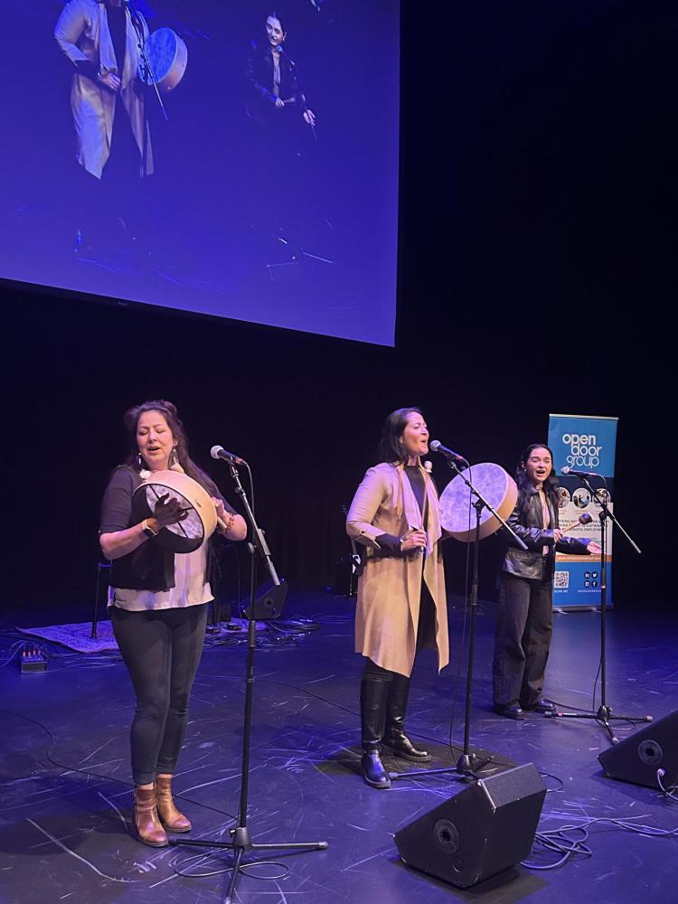 Three Indigenous women performing traditional Hand-drum songs with grace and skill.